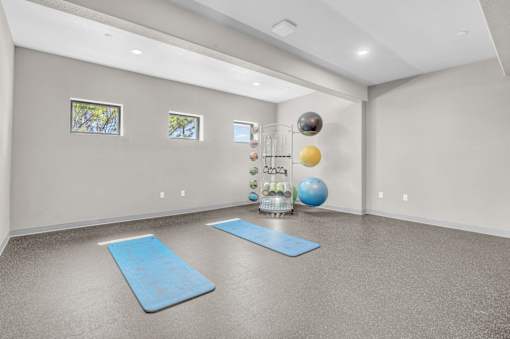 A room with a blue mat and a blue ball on the floor.