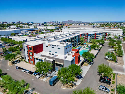 A parking lot with a building that has a red cross on it.