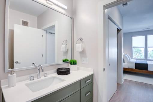 A bathroom with a white sink and a mirror above it.at The Ace, Richmond, 23230