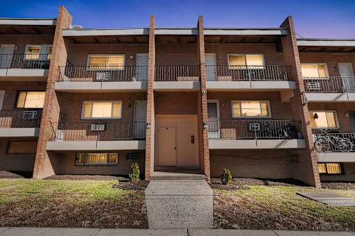 A multi-story apartment building with a brown door and balconies.