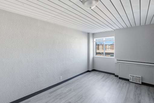 A room with a window and a radiator on the wall.