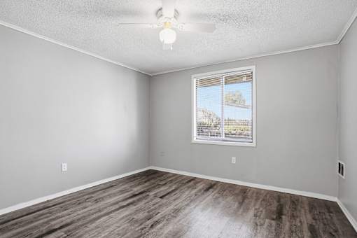 A room with a window and wooden flooring.