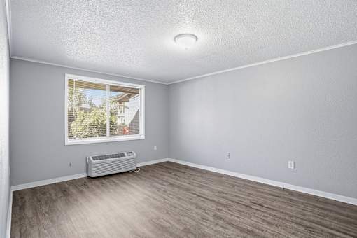 A room with a window and a wall-mounted air conditioner.