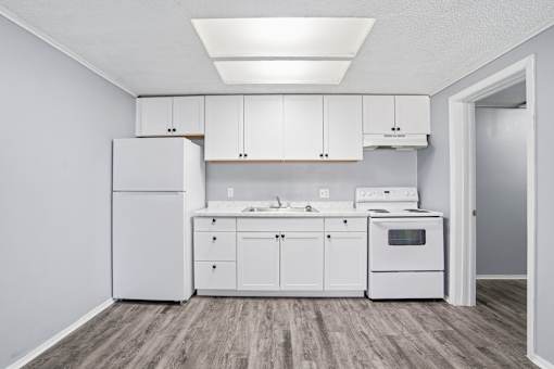 A kitchen with white appliances and cabinets.