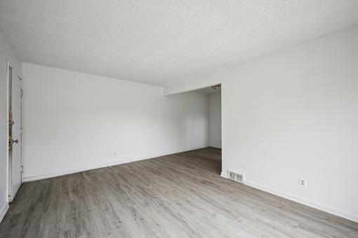 A room with a wooden floor and white walls.