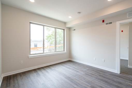 A room with a large window and a grey floor.