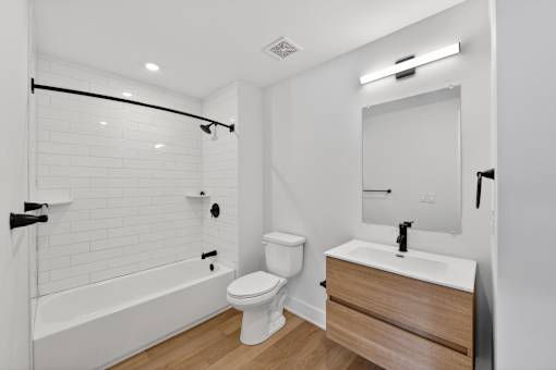 A white bathroom with a toilet, sink, and bathtub.