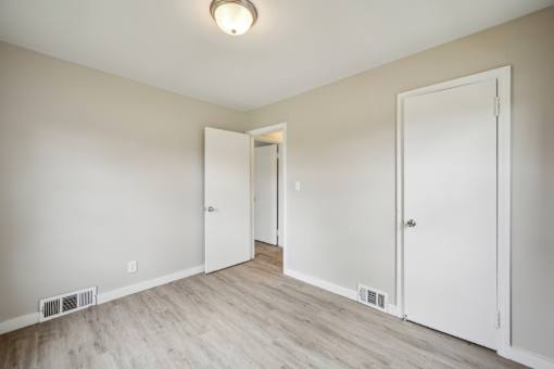 A room with white doors and a light on the ceiling.