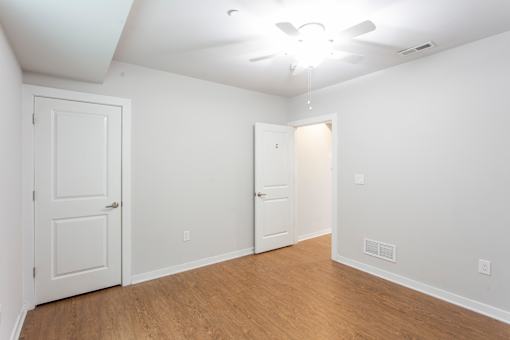 A room with two doors and a ceiling fan.