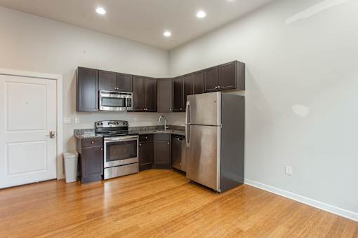 A kitchen with stainless steel appliances and wooden floors.