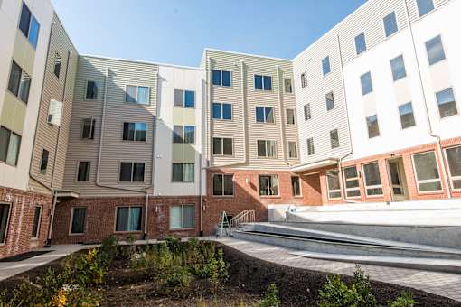 A modern building with a landscaped courtyard in front.