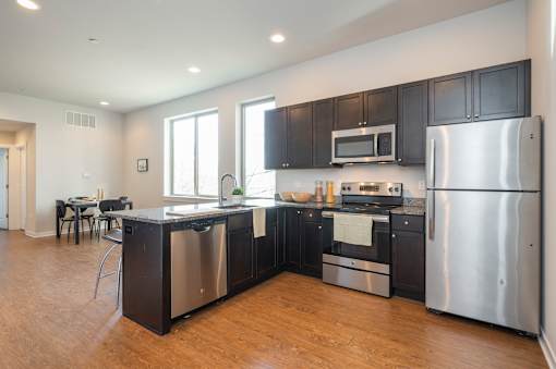 A modern kitchen with stainless steel appliances and black cabinets.