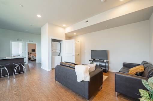 A living room with a black couch and a television.