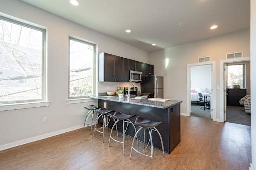 A kitchen with a bar stool and a counter.