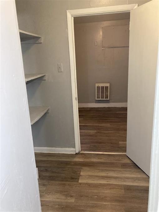 A room with a white door and a wood floor.