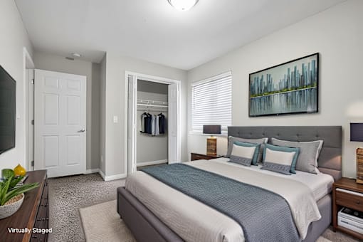 A bedroom with a bed, nightstands, and a painting on the wall.