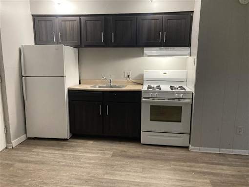A kitchen with a white refrigerator and a white stove top oven.