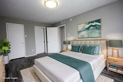 A bedroom with a large bed and a painting on the wall.