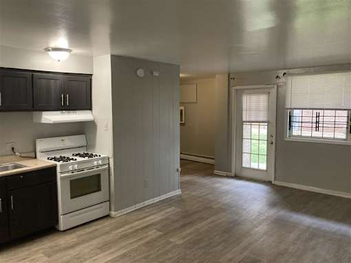 A kitchen with a white stove and black cabinets.