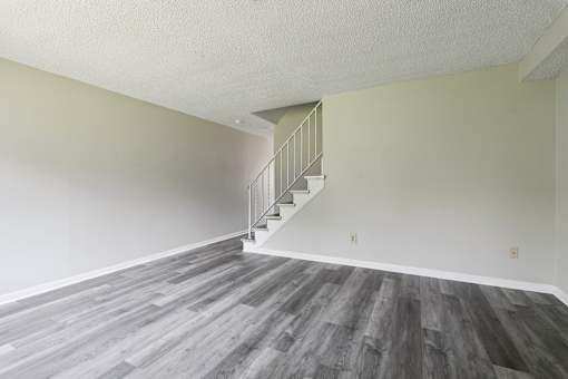 A room with a staircase and wooden flooring.