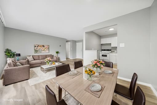 A modern dining room with a wooden table set for two.