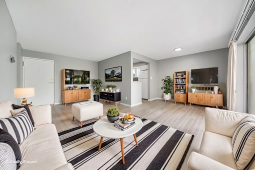 A living room with a white sofa, a coffee table, and a TV.