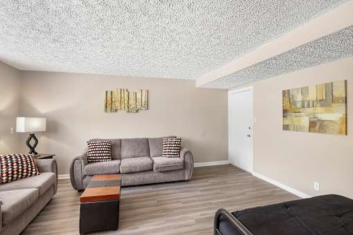 the living room of an apartment with a couch and a table