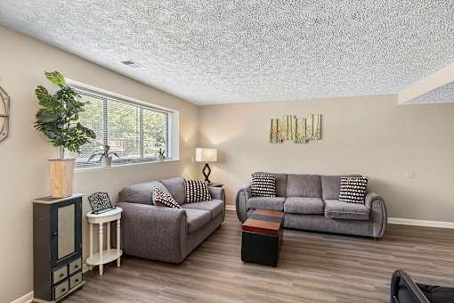 a living room with a couch and a chair and a window