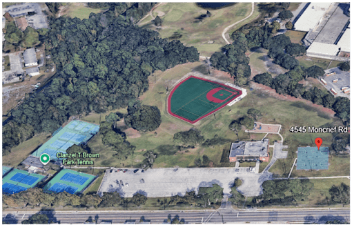An aerial view of a baseball field surrounded by trees and other buildings.