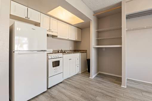 A white kitchen with a refrigerator, oven, and cabinets.