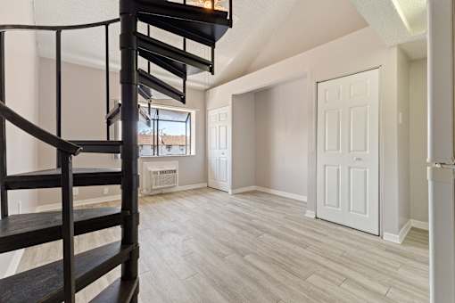 A room with a spiral staircase and a window.