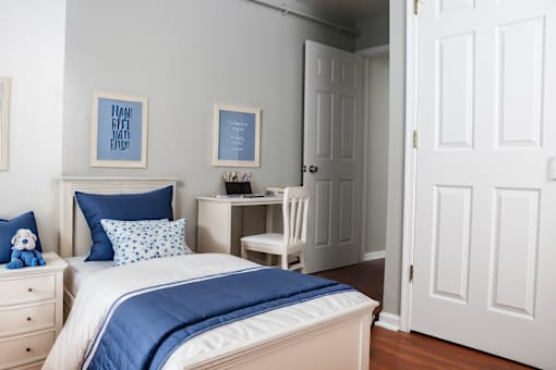 a bedroom with a bed and a desk with a chair