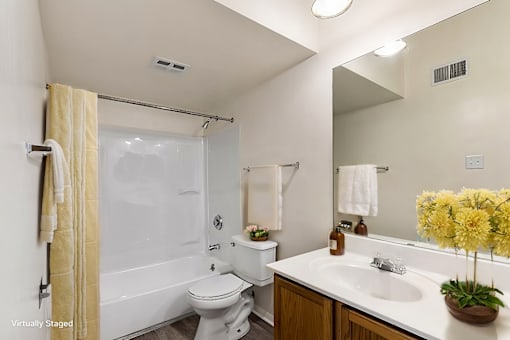 A bathroom with a white toilet, a white sink, and a yellow shower curtain.