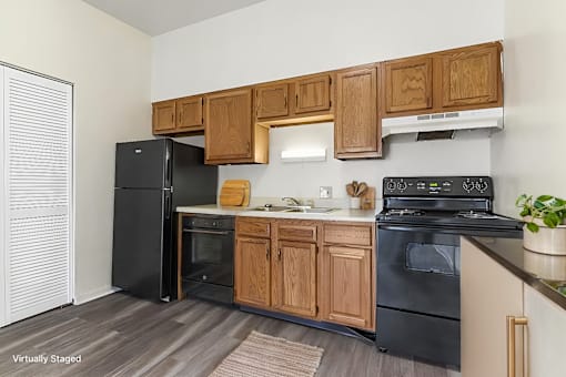 A kitchen with black appliances and wooden cabinets.