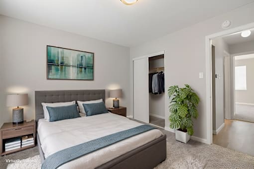 A bedroom with a large bed and a painting on the wall.