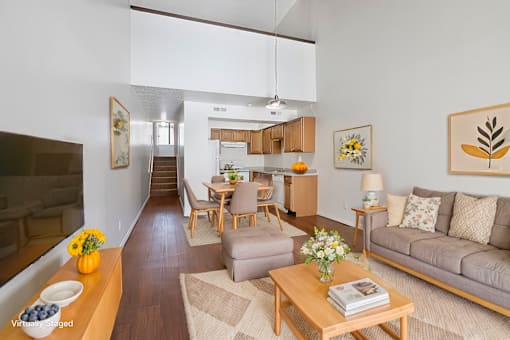 A living room with a couch, coffee table, and a dining table.