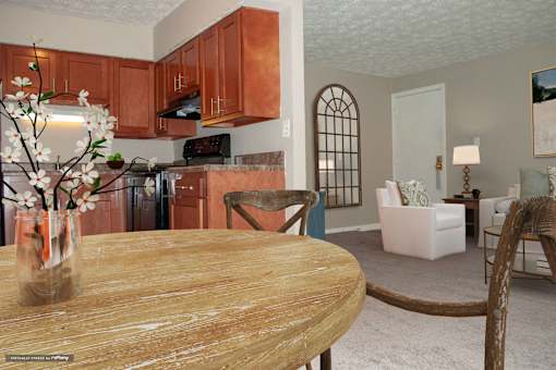 A kitchen with brown cabinets and a wooden table.