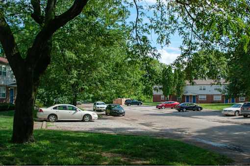 A white car is parked in a lot with other cars.