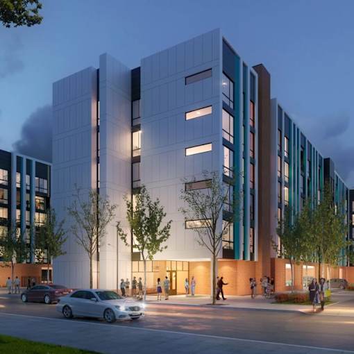 A modern building with a glass facade and a tree in front of it.
