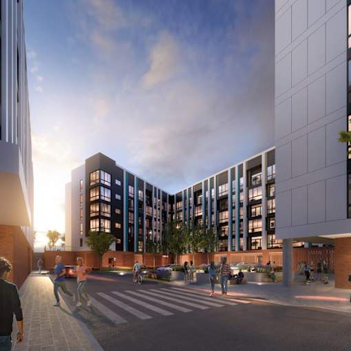 A modern building with a glass facade and a courtyard with people walking and sitting.