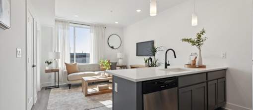 A modern kitchen with a large island and a view of the city.