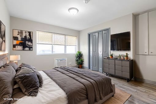 A bedroom with a large bed and a dresser.