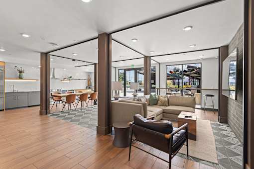 A modern living room with a kitchen area in the background.