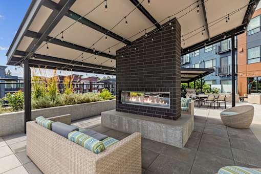 A modern outdoor seating area with a fireplace.