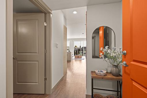A hallway with a wooden floor and white walls.