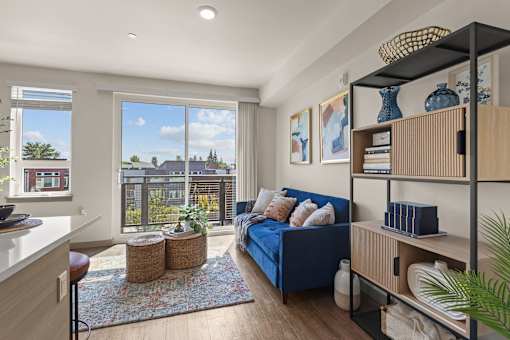 A living room with a blue couch and a large window.