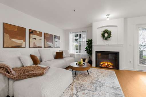 A cozy living room with a fireplace and a wreath on the mantle.