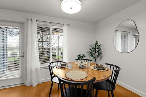 A dining room with a round table set for two.