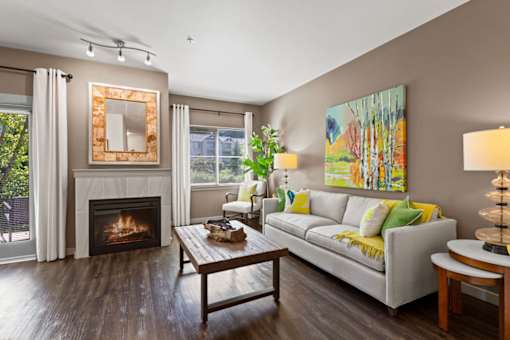 A living room with a fireplace and a painting on the wall.