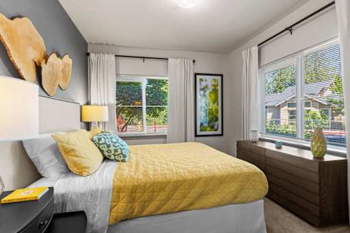 A bedroom with a bed, nightstand, and window.
